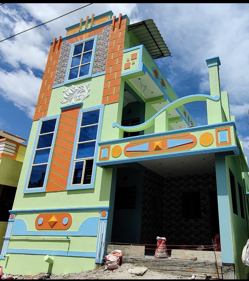 Ornate green, orange and blue architectural facade design on a VK Builders house, Chennai