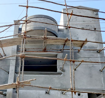 Three-storey building under construction with workers on bamboo scaffolding, VK Builders site