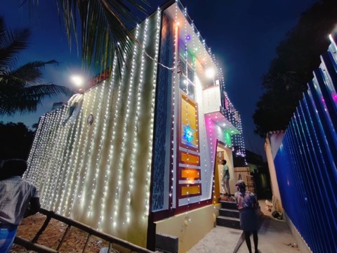 Completed VK Builders house decorated with string lights at night for handover