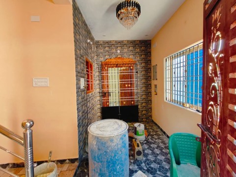 Interior hallway with a crystal chandelier and decorative stone-pattern wall, VK Builders interior work