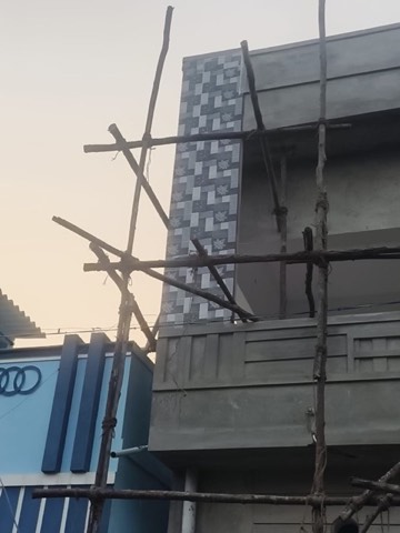 Scaffolding against a building during elevation tile-cladding work, VK Builders site